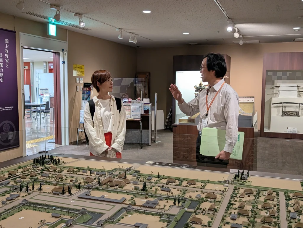 江戸時代の長岡城下町のジオラマを前に真剣に耳を傾けます